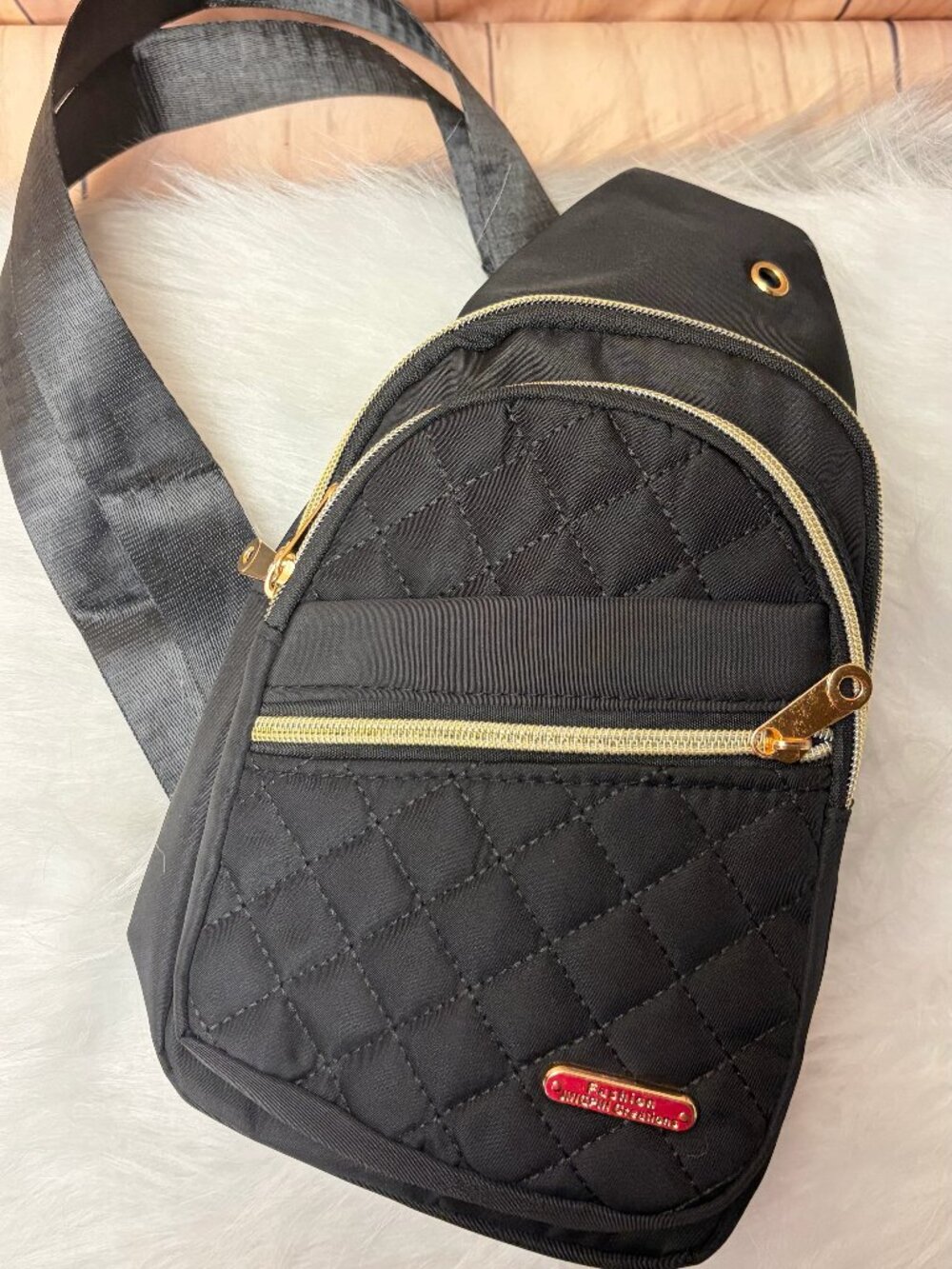 Black quilted crossbody sling bag featuring a diamond-stitched front